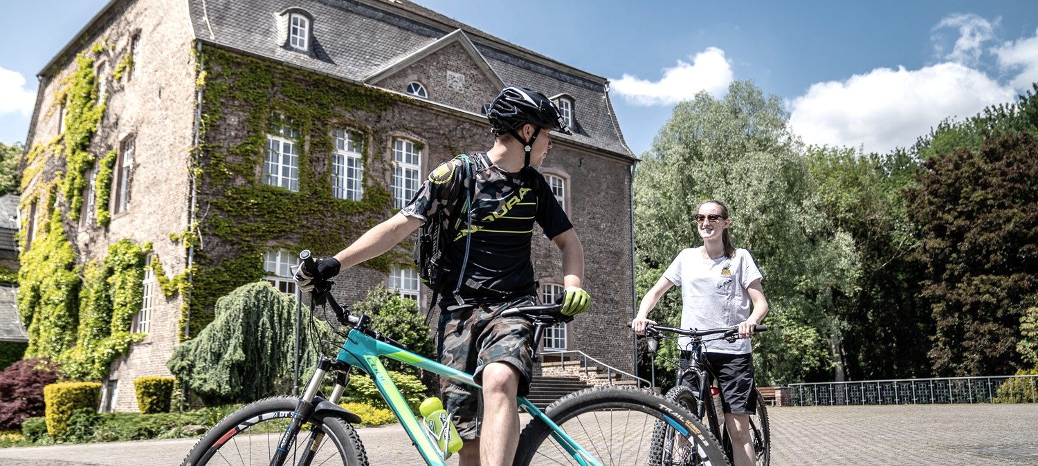 Radfahrer am Haus Overbach, © Dennis Stratmann | Kreis Düren