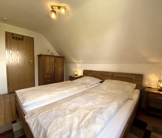 Schlafzimmer mit Doppelbett und kleinem Schrank, © Rureifel Tourismus e.V.
